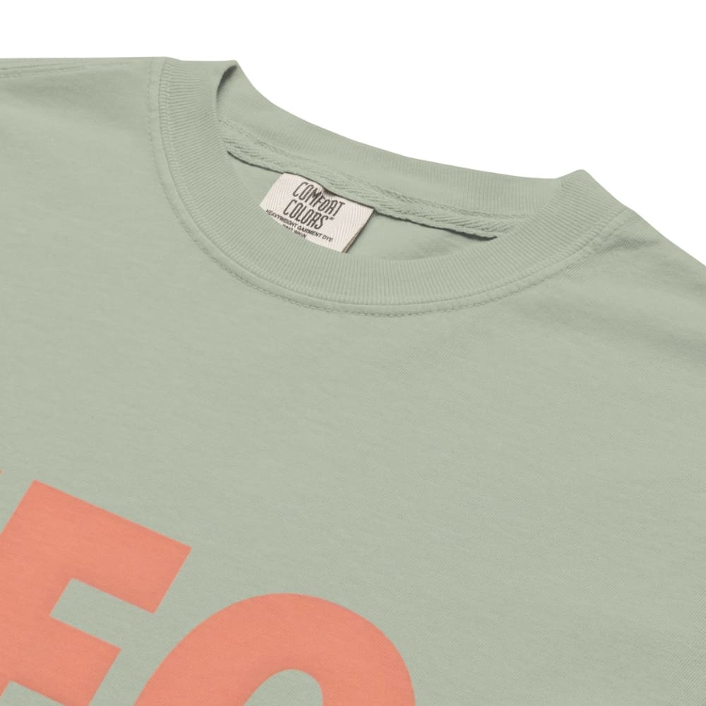 CEO of the Chaos” printed on a heavyweight cotton t-shirt in soft pastel ink, laid flat with a minimal lifestyle background.