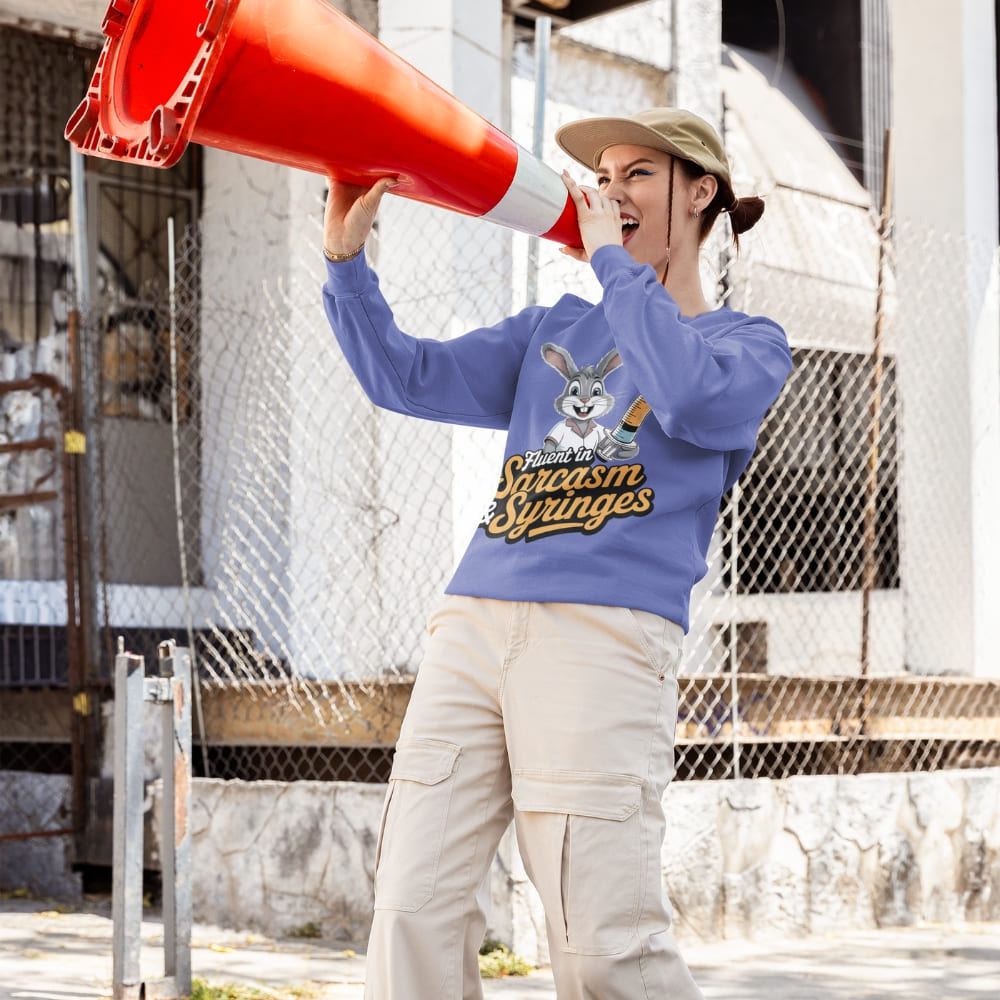 Person wearing a blue sweatshirt with a graphic design, holding a red megaphone outdoors.
