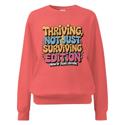 Coral sweatshirt with colorful text design on a white background