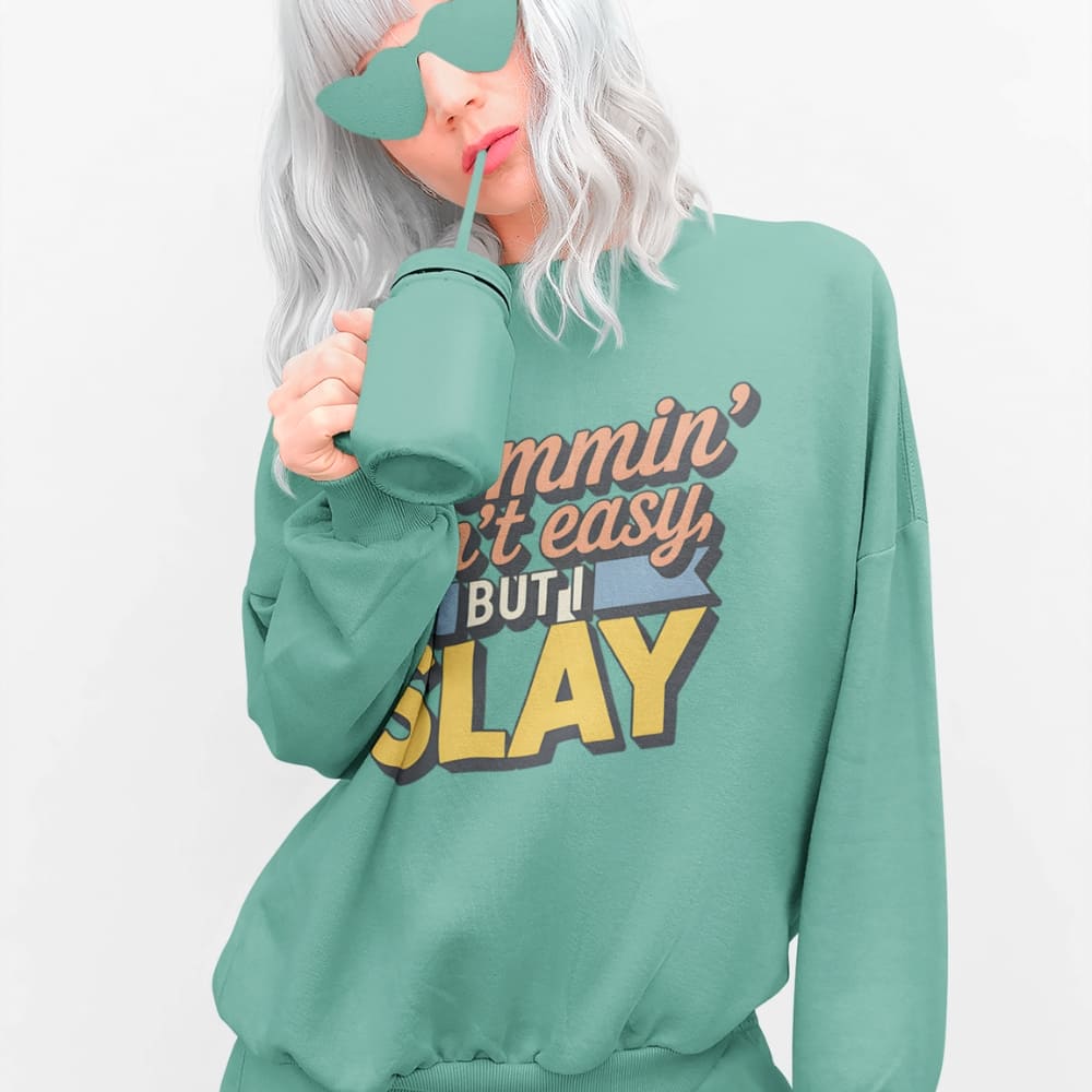 “Mommin' Ain’t Easy But I Slay” retro-style DTG printed design in peach, blue, and yellow on vintage garment-dyed fleece sweatshirt