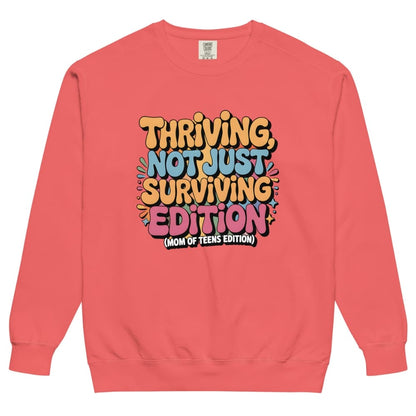 Coral sweatshirt with colorful text design on a white background