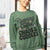 Person wearing a green sweatshirt with text 'Running on Coffee, Chaos & Cuddles' in a casual setting.