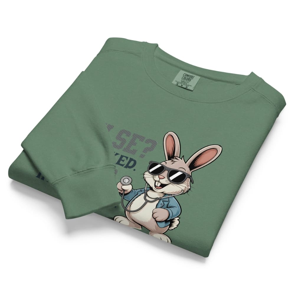 Folded green sweatshirt with cartoon rabbit design and text on a white background
