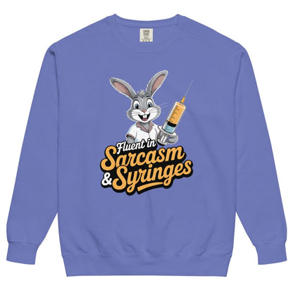 Blue sweatshirt with cartoon character holding a syringe and text 'Fluent in Sarcasm & Syringes' on a white background