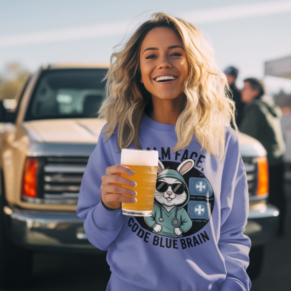 Woman holding a beer in front of a truck with a 'Code Blue Brain' graphic on her sweatshirt.
