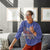 Person wearing a colorful sweatshirt in a living room setting