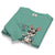Folded teal sweatshirt with cartoon rabbit design and text on a white background