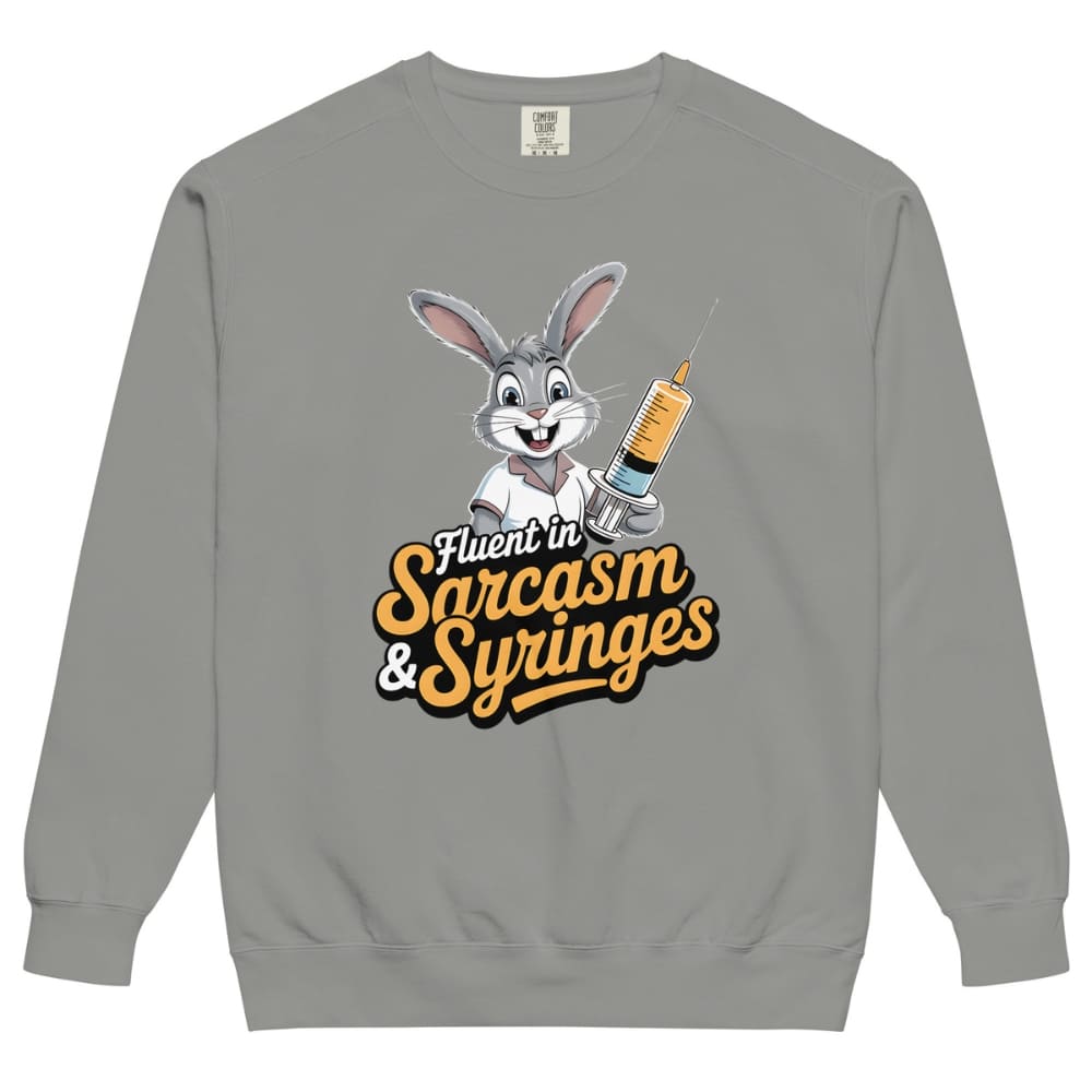 Gray sweatshirt with cartoon character holding a syringe and text ' Fluent in Sarcasm & Syringes' on a white background