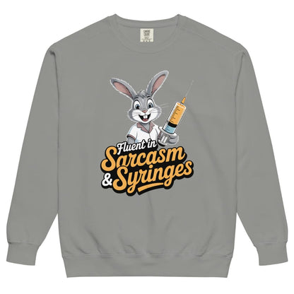 Gray sweatshirt with cartoon character holding a syringe and text ' Fluent in Sarcasm & Syringes' on a white background