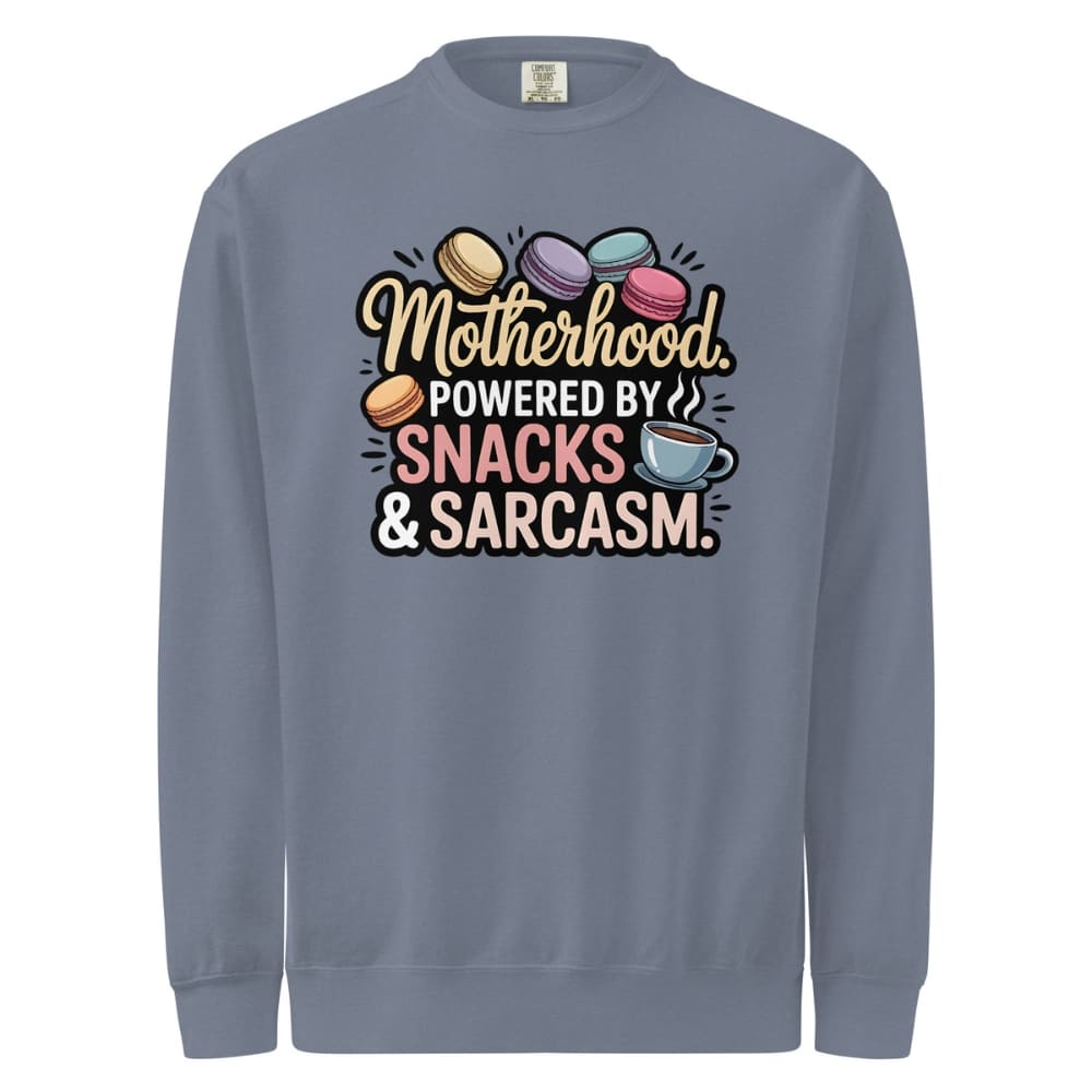 Sweatshirt design with text “Motherhood. Powered by Snacks & Sarcasm.” featuring colorful macarons and a steaming coffee cup on vintage-washed cotton fleece.