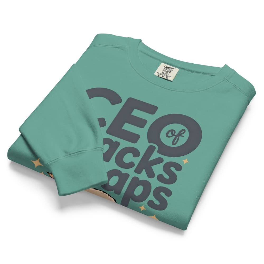 "CEO of Snacks & Naps" printed sweatshirt featuring a sloth in a crown surrounded by pretzels and plushies on vintage-washed cotton fleece