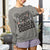 Person wearing a gray sweatshirt with text 'Running on Coffee, Chaos & Cuddles' in a home setting.
