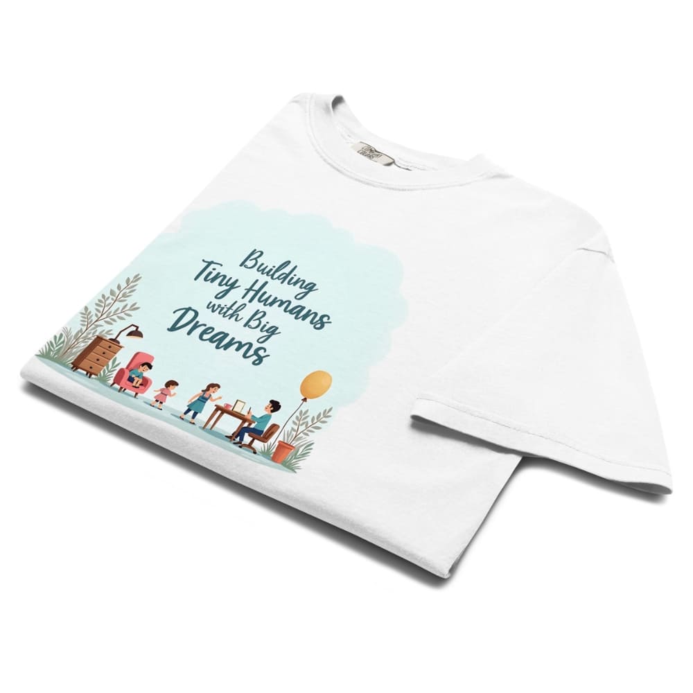 Illustrated t-shirt design with the quote "Building Tiny Humans with Big Dreams" surrounded by a family parenting scene
