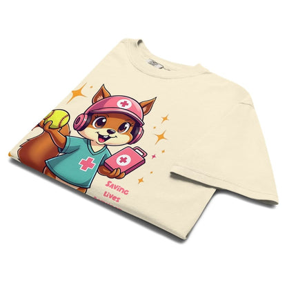 Cute squirrel nurse cartoon in scrubs, pink cap, and headset holding a softball and medical kit with the phrase “Saving Lives Between Innings” — printed on a heavyweight cotton t-shirt