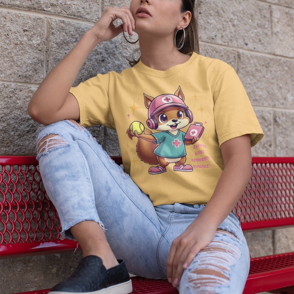 Cute squirrel nurse cartoon in scrubs, pink cap, and headset holding a softball and medical kit with the phrase “Saving Lives Between Innings” — printed on a heavyweight cotton t-shirt