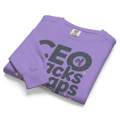 "CEO of Snacks & Naps" printed sweatshirt featuring a sloth in a crown surrounded by pretzels and plushies on vintage-washed cotton fleece