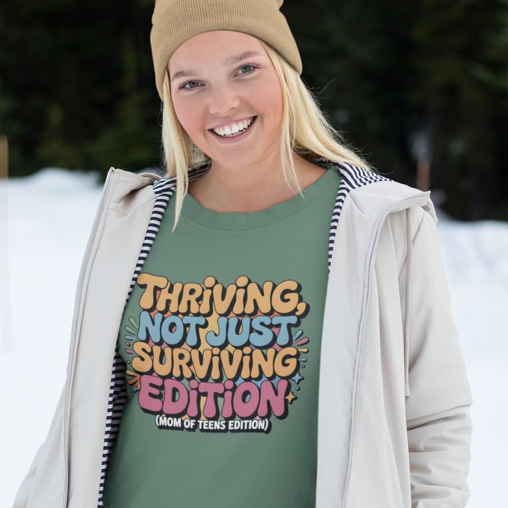 Person wearing a green t-shirt with colorful text in a snowy outdoor setting