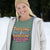 Person wearing a green t-shirt with colorful text in a snowy outdoor setting
