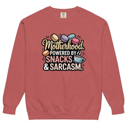 Sweatshirt design with text “Motherhood. Powered by Snacks & Sarcasm.” featuring colorful macarons and a steaming coffee cup on vintage-washed cotton fleece.