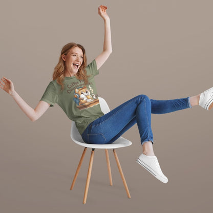 Person wearing a green t-shirt with a graphic design, sitting on a white chair against a beige background