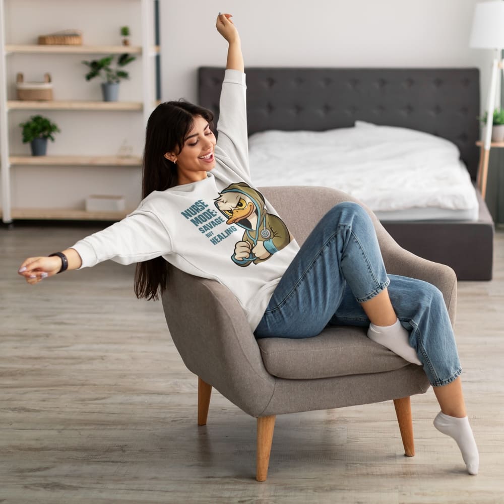 Woman sitting on a chair wearing a sweatshirt with a graphic design in a bedroom.