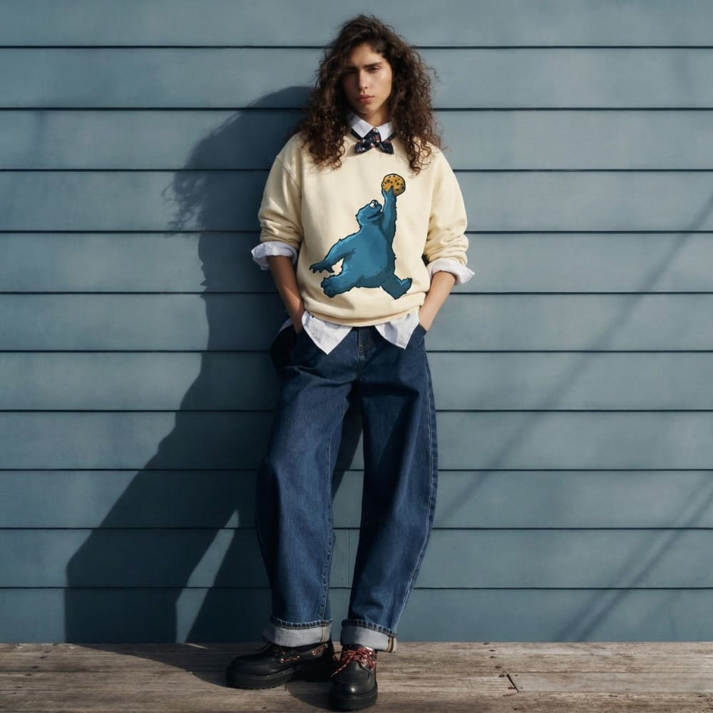Person wearing a sweater with a bear graphic against a wooden wall