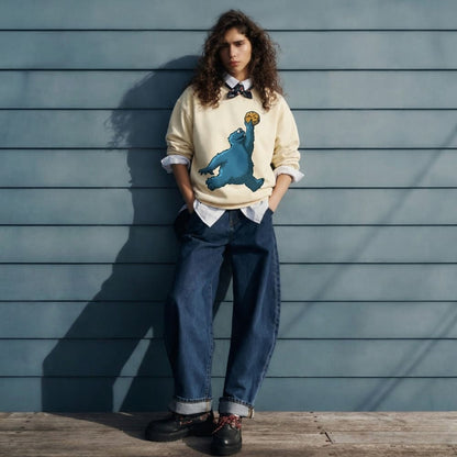 Person wearing a sweater with a bear graphic against a wooden wall