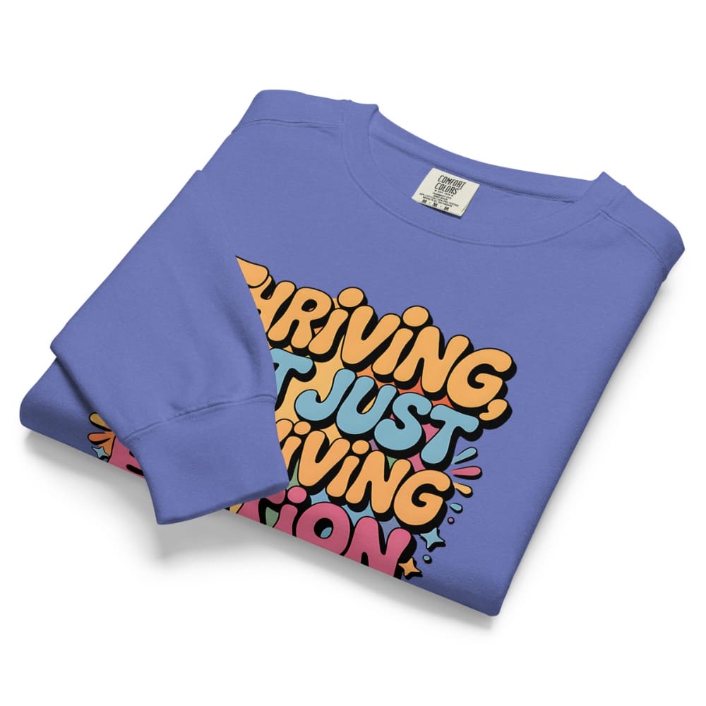 Folded blue sweatshirt with colorful text design on a white background