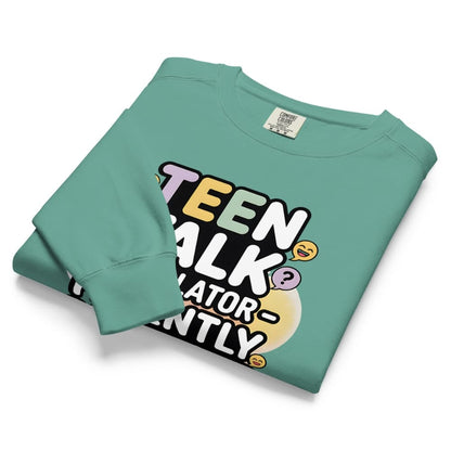Folded teal sweatshirt with colorful text design on a white background