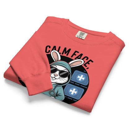 Folded red sweatshirt with a graphic of a rabbit in a hoodie and sunglasses on a white background