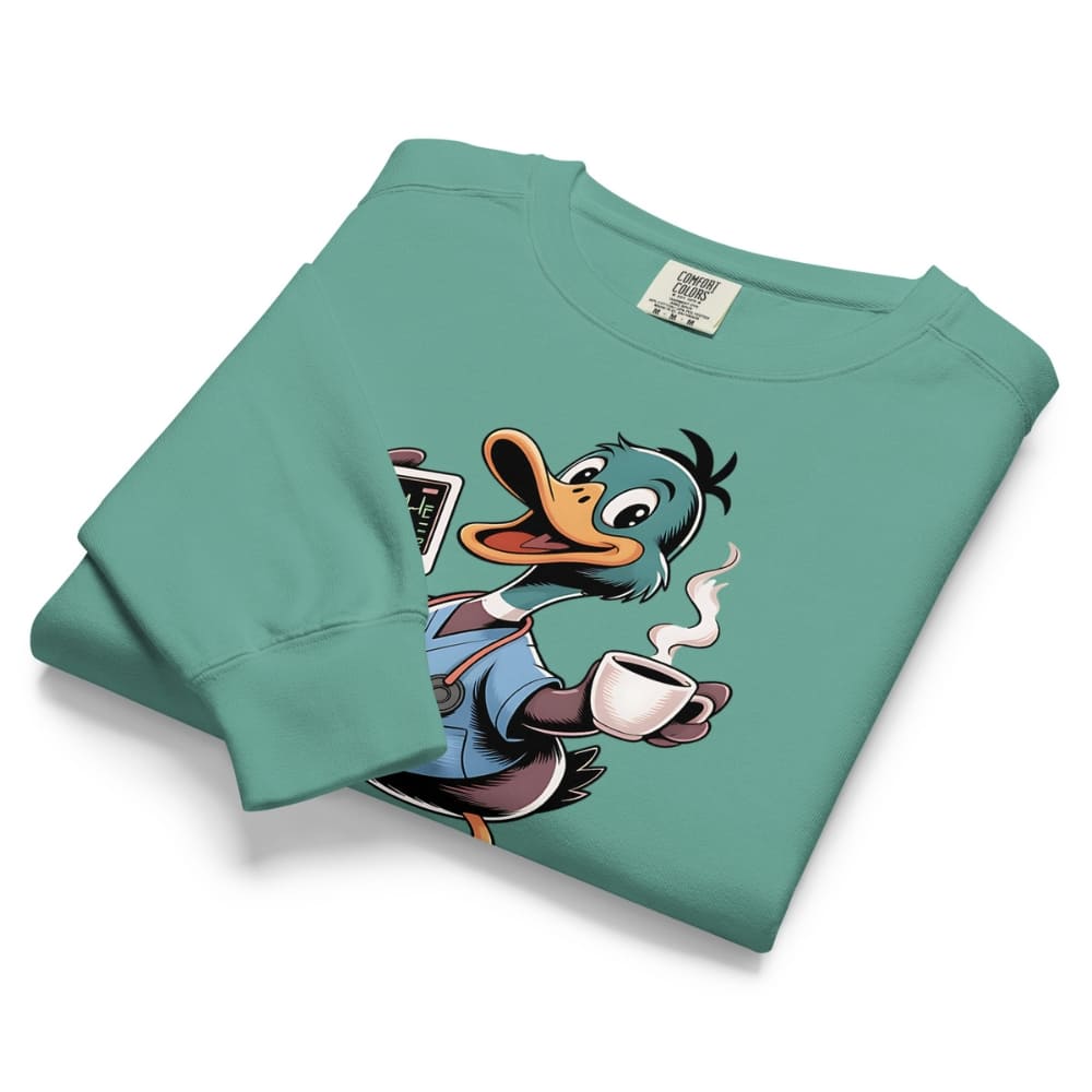 Folded teal sweatshirt with cartoon duck design holding a coffee cup on a white background