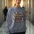 Sweatshirt design with text “Motherhood. Powered by Snacks & Sarcasm.” featuring colorful macarons and a steaming coffee cup on vintage-washed cotton fleece.