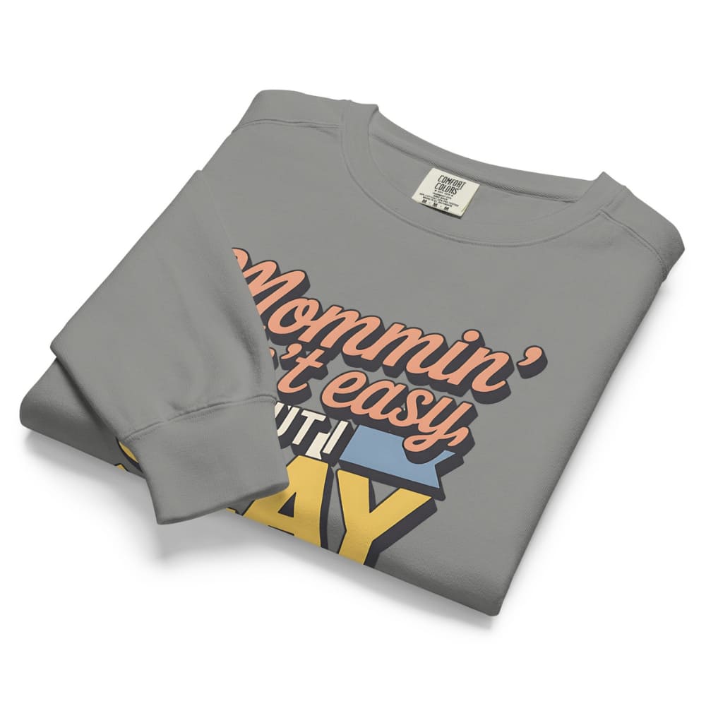 “Mommin' Ain’t Easy But I Slay” retro-style DTG printed design in peach, blue, and yellow on vintage garment-dyed fleece sweatshirt