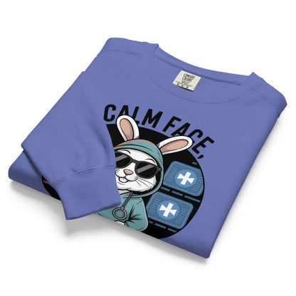 Folded blue sweatshirt with a graphic of a rabbit and text on a white background