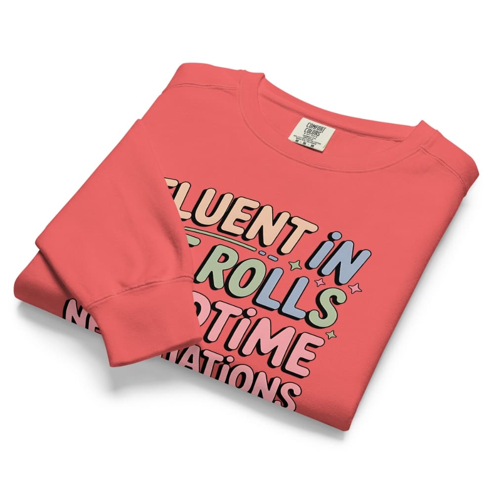 Folded pink sweatshirt with colorful text design on a white background