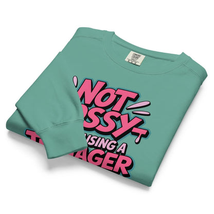 Folded teal sweatshirt with pink and black text on a white background