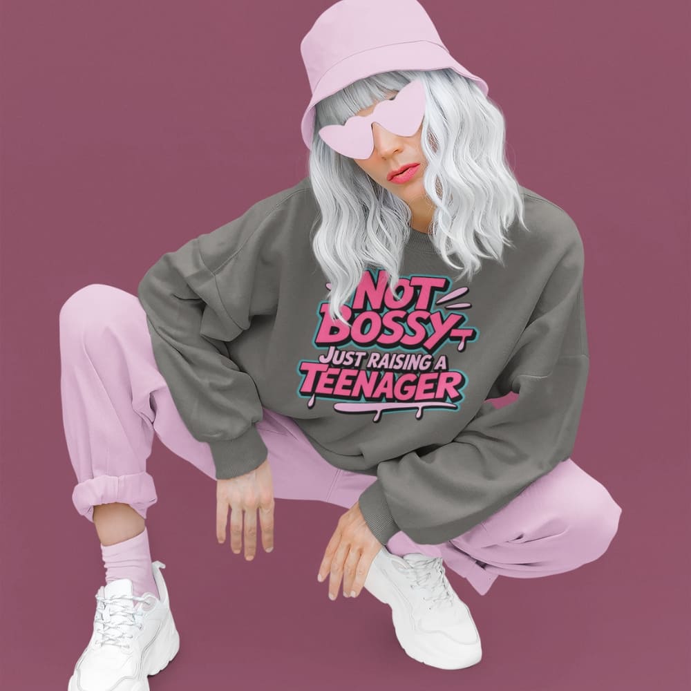 Person wearing a sweatshirt with text, pink hat, and heart-shaped sunglasses on a purple background