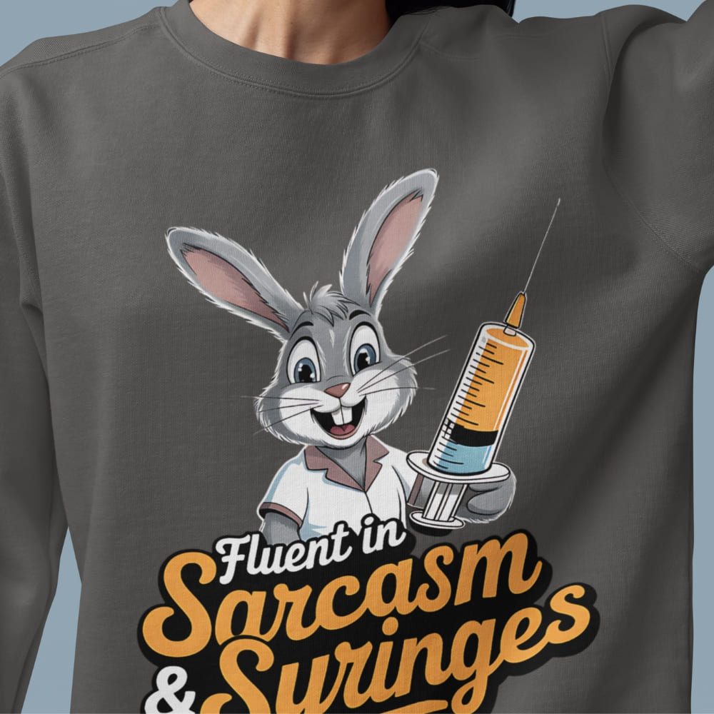 Gray sweatshirt with cartoon rabbit holding a syringe and text 'Fluent in Sarcasm & Swinges' on a blue background