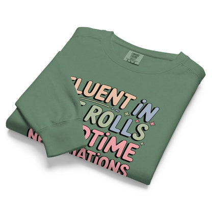Folded green sweatshirt with colorful text design on a white background