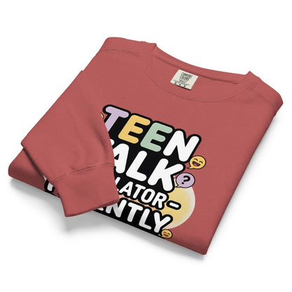 Folded red sweatshirt with colorful text design on a white background