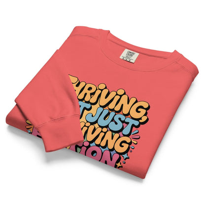 Folded pink sweatshirt with colorful text design on a white background
