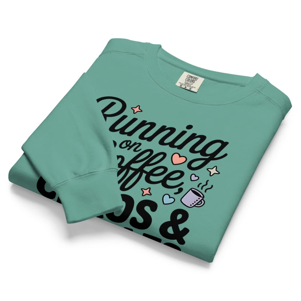 Folded teal sweatshirt with text and graphics on a white background