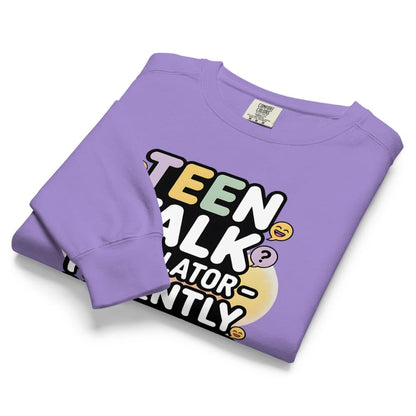 Folded purple sweatshirt with colorful text design on a white background