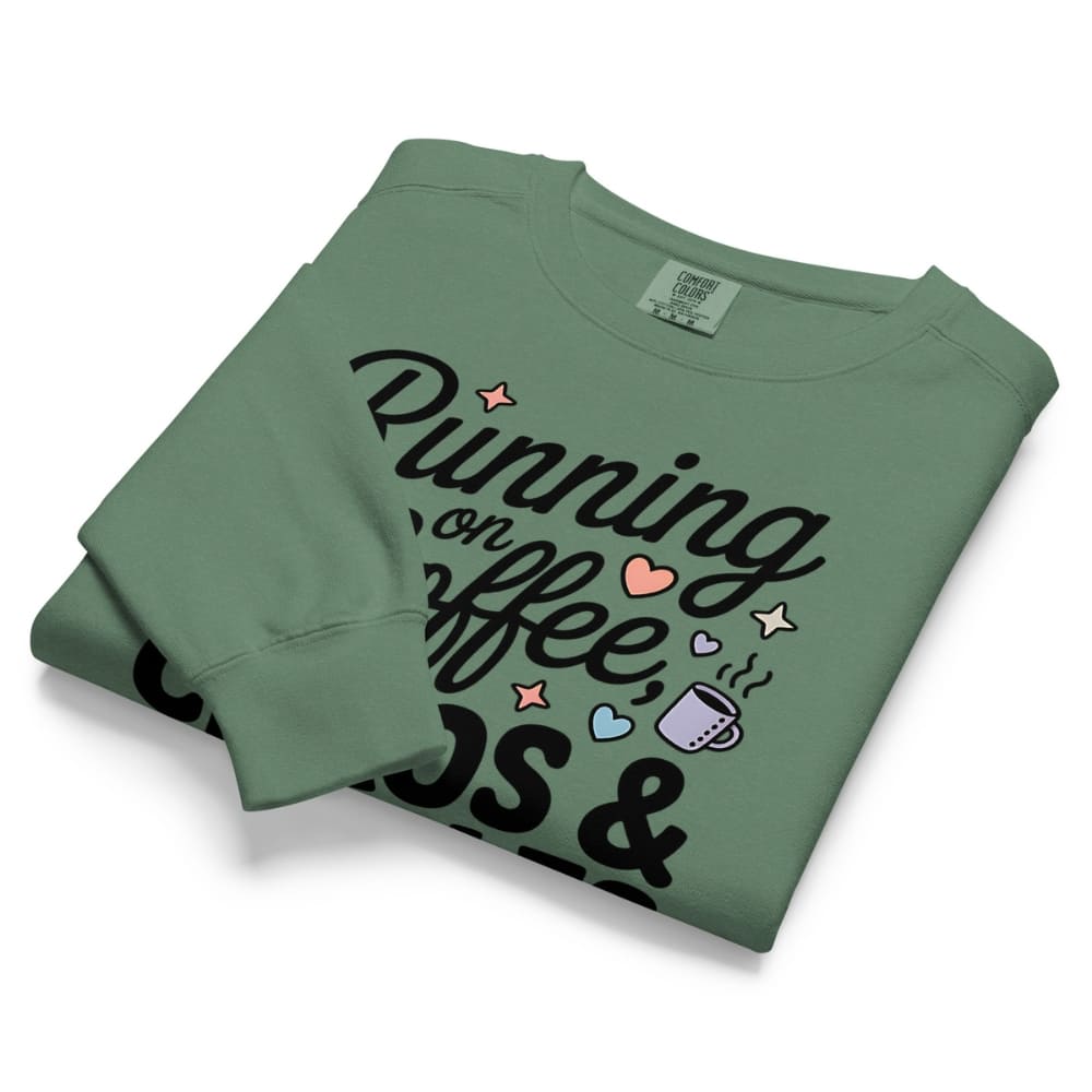Folded green sweatshirt with text and graphics on a white background