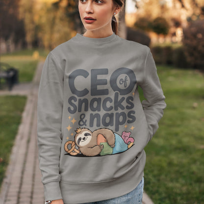 "CEO of Snacks & Naps" printed sweatshirt featuring a sloth in a crown surrounded by pretzels and plushies on vintage-washed cotton fleece