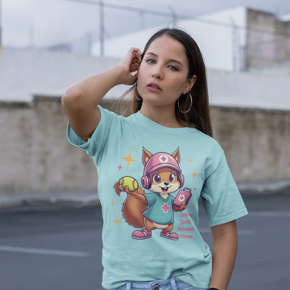 Cute squirrel nurse cartoon in scrubs, pink cap, and headset holding a softball and medical kit with the phrase “Saving Lives Between Innings” — printed on a heavyweight cotton t-shirt
