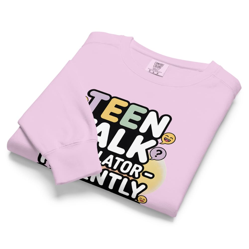 Folded pink sweatshirt with colorful text design on a white background