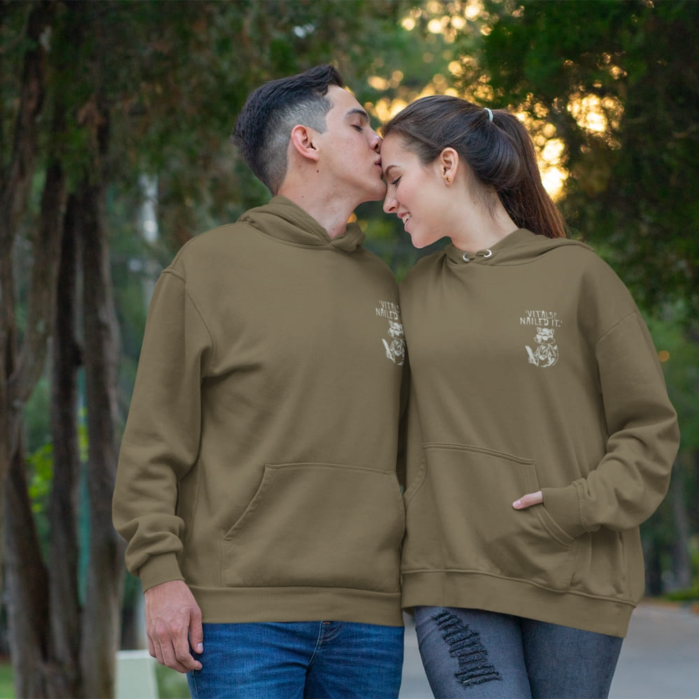 Raccoon nurse graphic wearing scrubs and sunglasses holding a clipboard under the quote “Vitals? Nailed It.” – printed on a black Cotton Heritage hoodie