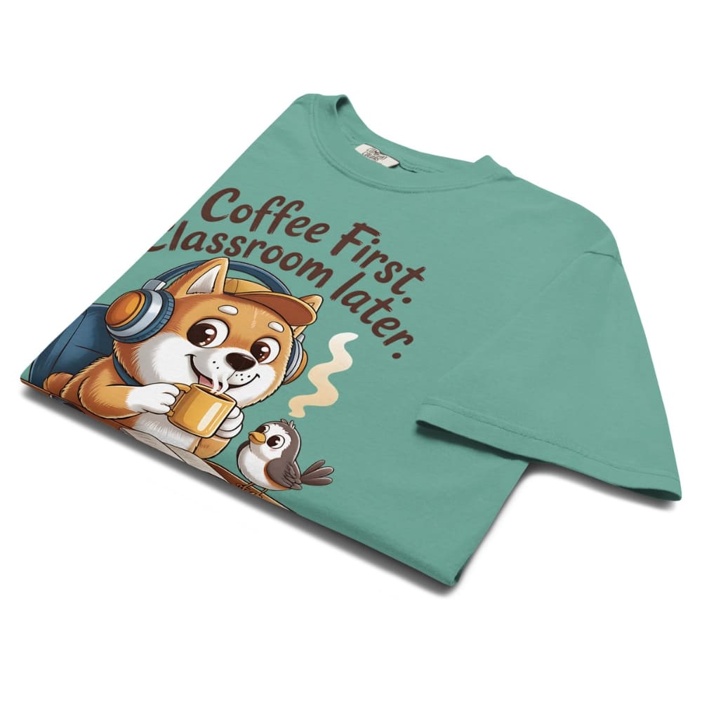 Green t-shirt with a dog and owl graphic and text 'Coffee First, Classroom Later' on a white background