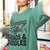 Person wearing a green t-shirt with text 'Running on Coffee, Chaos & Cuddles' in an indoor setting.